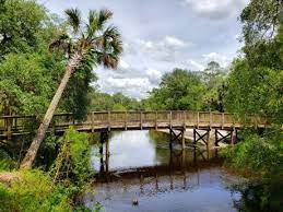 A wooden foot bridge leading over a wide river in Geneva, Florida. Geneva, Florida is a location served by Johannessen Lights.