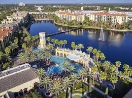 An aerial photograph of Lake Buena Vista, Florida. Palm trees surround a pool on a property next to the water. Lake Buena Vista, Florida is a location served by Johannessen Lights.