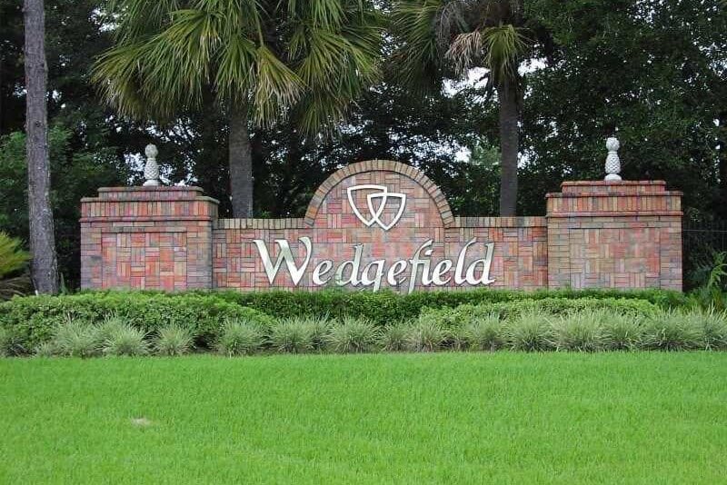 An ornate brick wall with the signage "Wedgefield" on the front in Wedgefield, Florida. Wedgefield, Florida is a location served by Johannessen Lights.