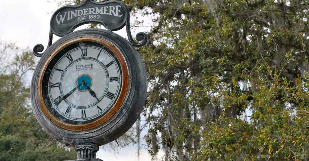 A simple, but ornate iron clock post with a sign on the top reading "WINDERMERE Est. 1889" in Windermere, Florida. Windermere, Florida is a location served by Johannessen Lights.